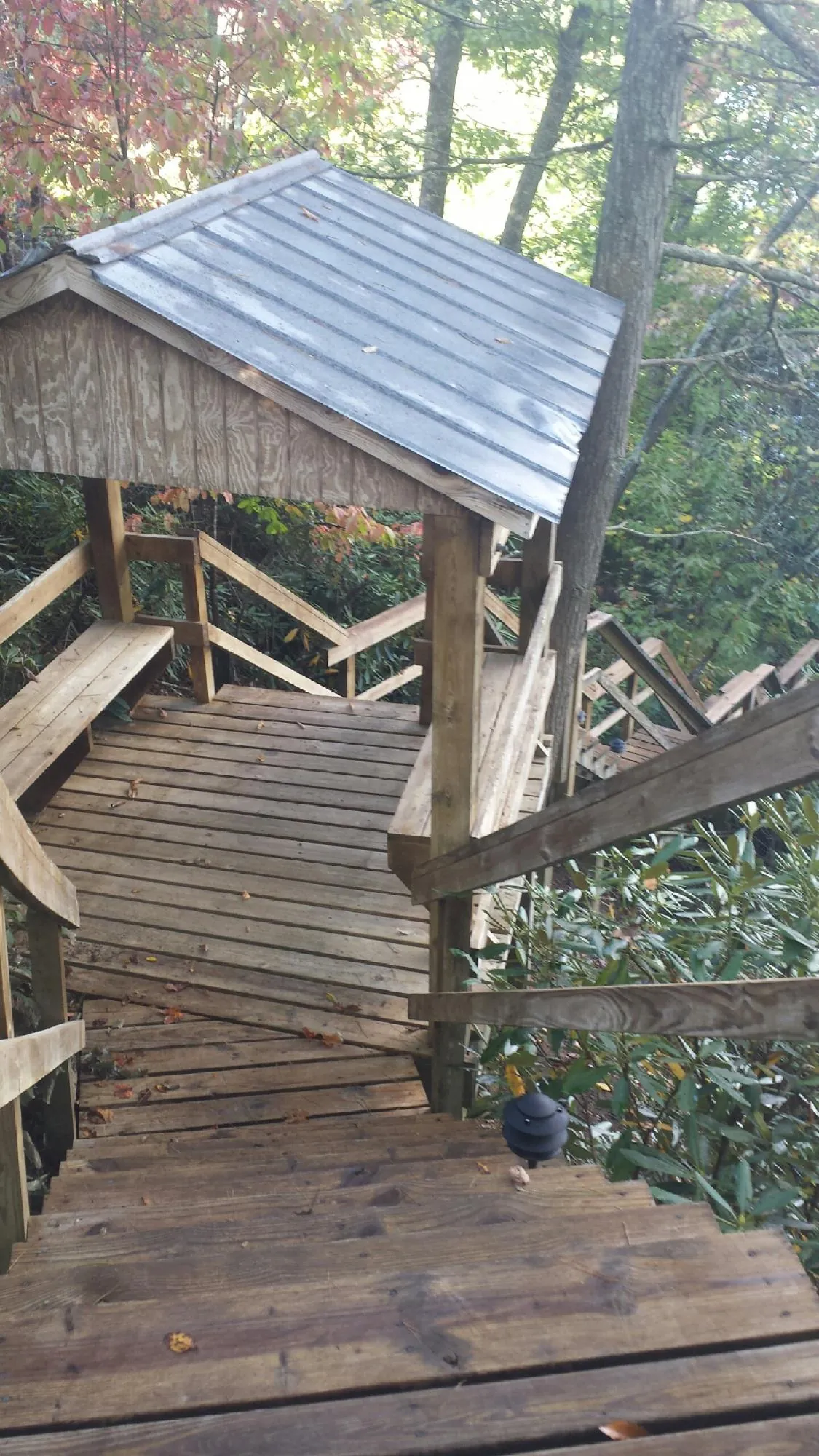 Metal roofed shelter over wooden steps on a wooded walkway — Skylight Repair & Installation work by our crew in Wilton
